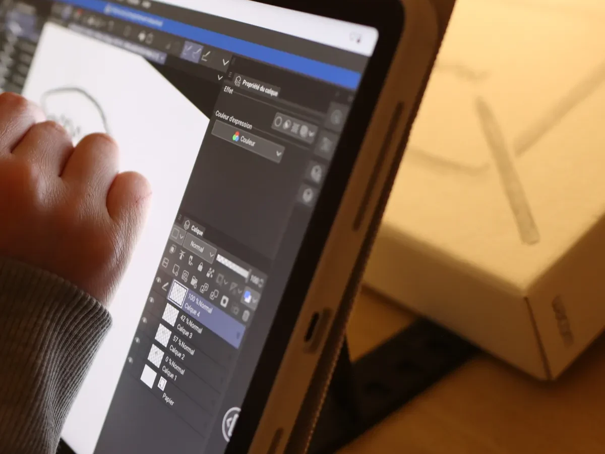 Main dessinant au stylet sur une tablette Wacom pendant un cours