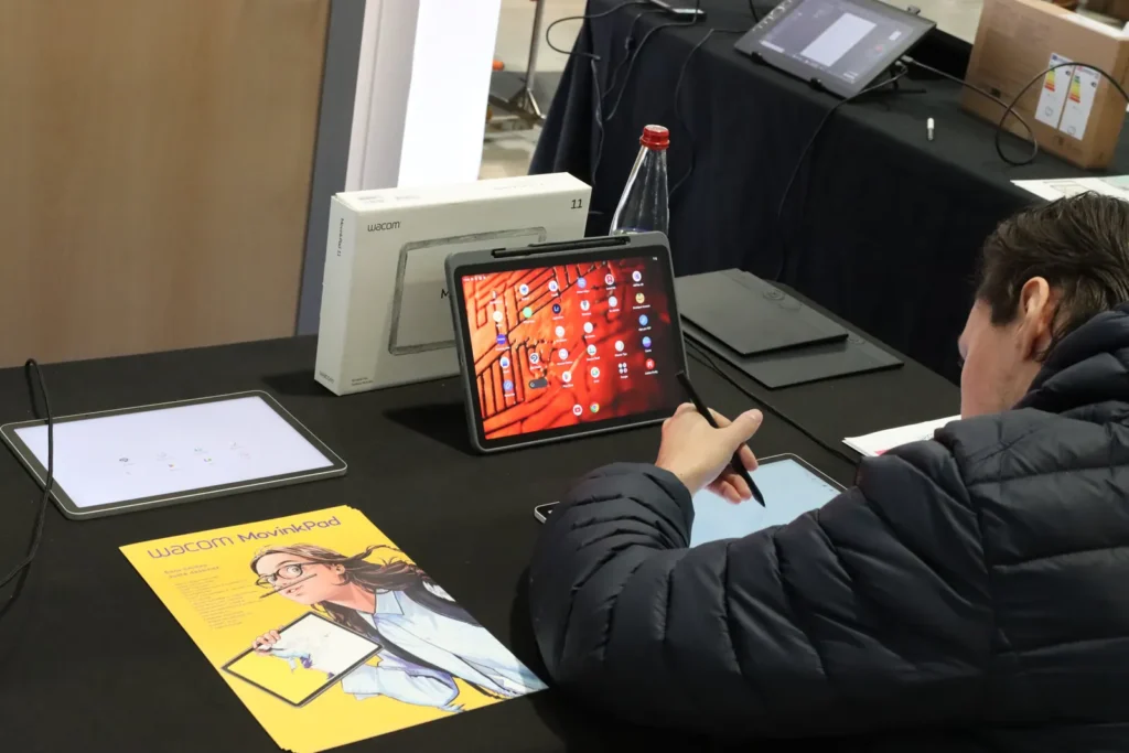Un visiteur essaie la tablette Wacom MovinkPad sur un stand
